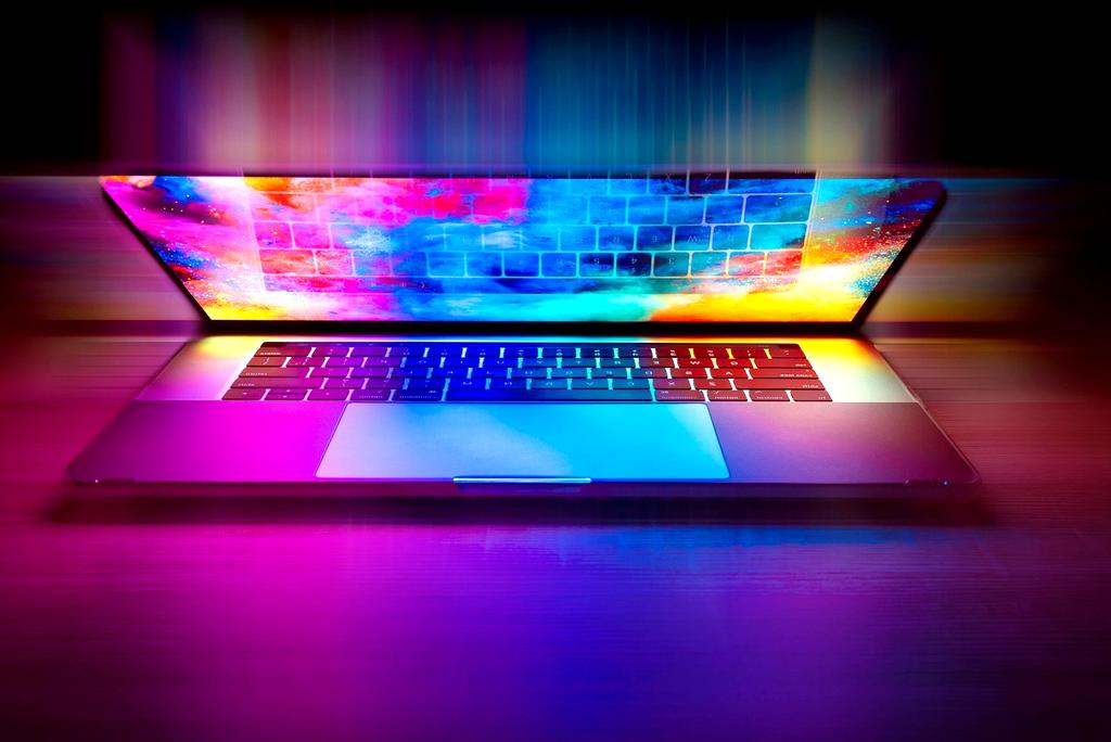 Modern laptop on a wooden desk with tech gadgets